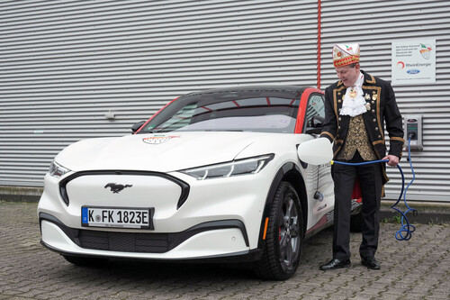 Christoph Kuckelkorn, Präsident des Festkomitees Kölner Karneval, lädt seinen neuen Dienstwagen, den vollelektrischen Ford Mustang Mach-E.