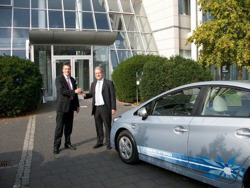 Sascha van Gool, Key Account Manager, Toyota Geschäftskunden Services, übergibt die Autoschlüssel für den Prius Plug-In Hybrid an Reinhard Hüning,Business Development Manager Public Sector, LeasePlan Deutschland GmbH.