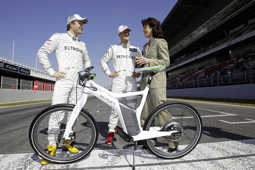 Smart-Cheffin Dr. Annette Winkler überreicht Nico Rosberg (links) und Michael Schumacher das Smart Ebike.