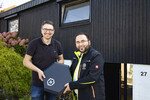 Cubos begrüßt den 1000. Kunden: Markus Schuchardt (re.) überreicht Frederik Gutermilch seine Cubos Wallbox C11E Premium.